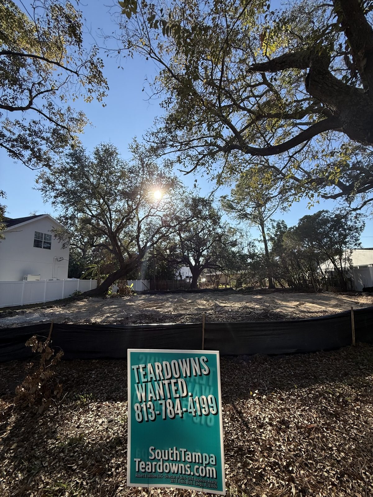 Cleared South Tampa lot under live oaks, with a Teardowns Wanted sign