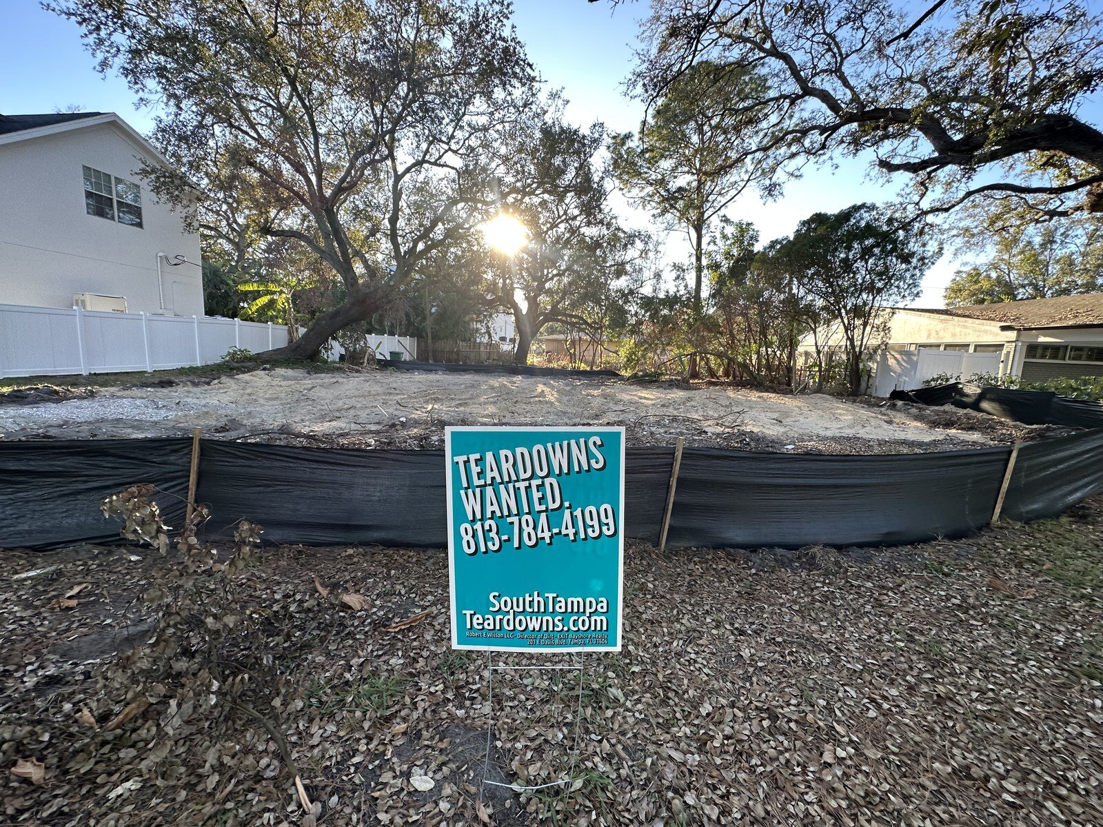 Cleared South Tampa lot behind a silt fence with a Teardowns Wanted sign