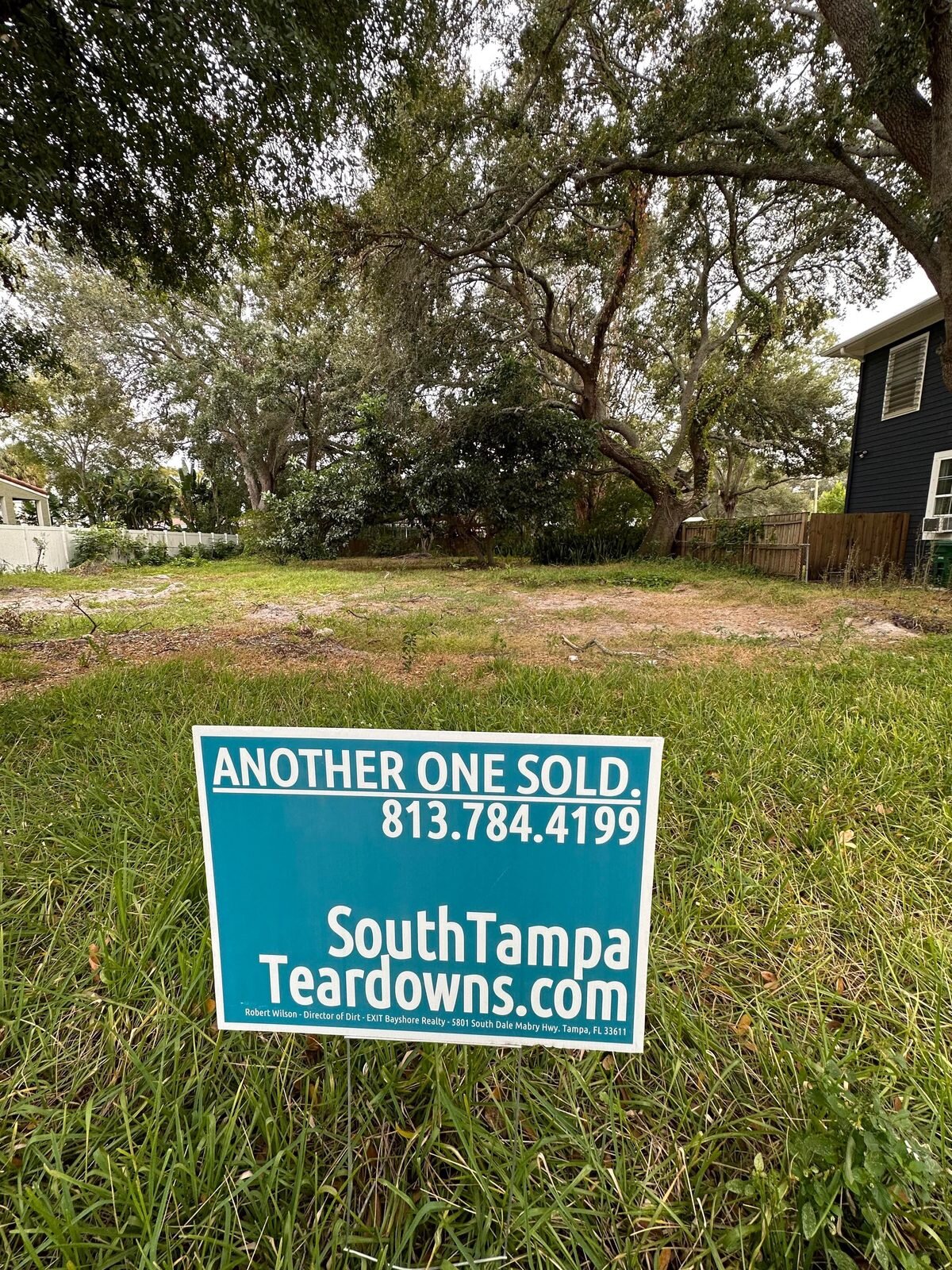 Grassy South Tampa lot under oak trees with an Another One Sold sign