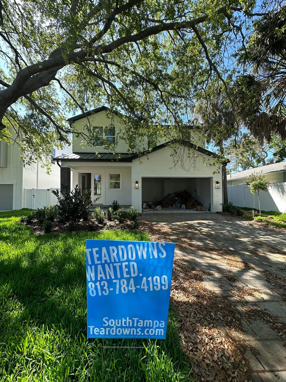 Finished new Tampa house under an oak tree with a Teardowns Wanted sign