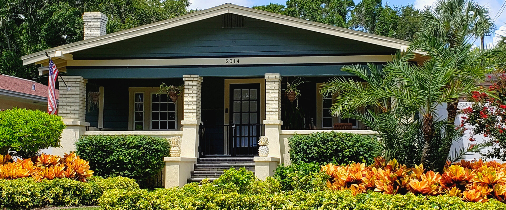 Mid-century home with palm trees and brick exterior