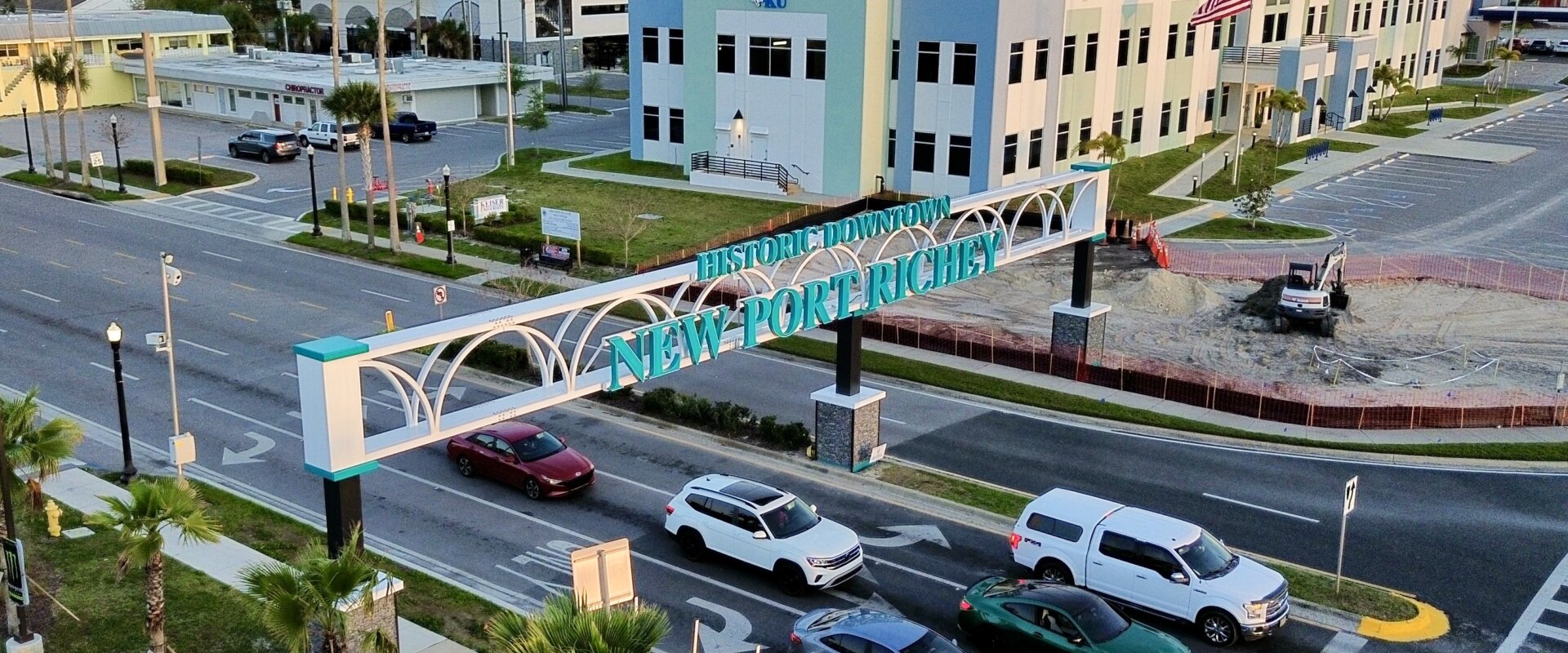 welcome sign with New Port Richey in blue text over busy traffic intersection
