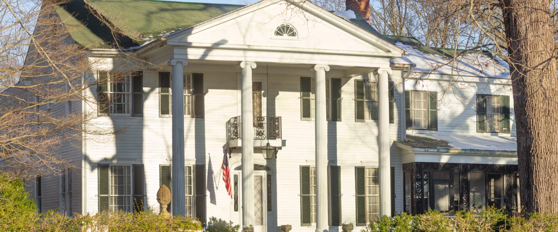 white colonial-style home with columns and green roof in Germantown, Tennessee