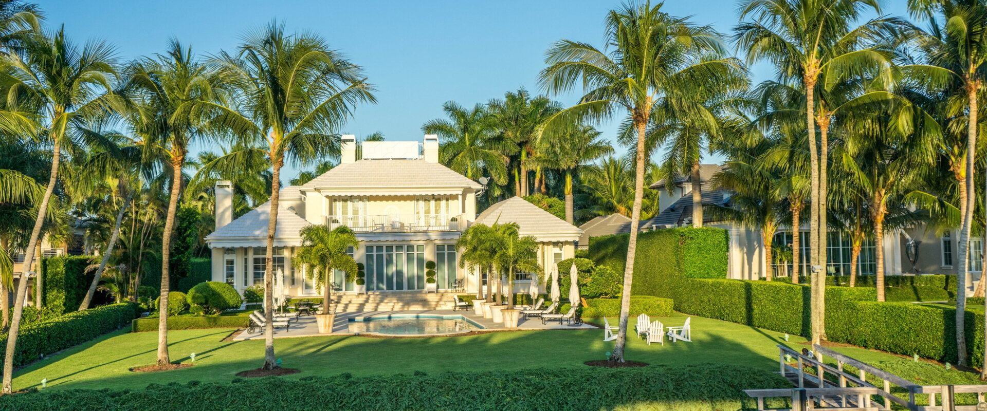 luxury waterfront home with palm trees and private dock