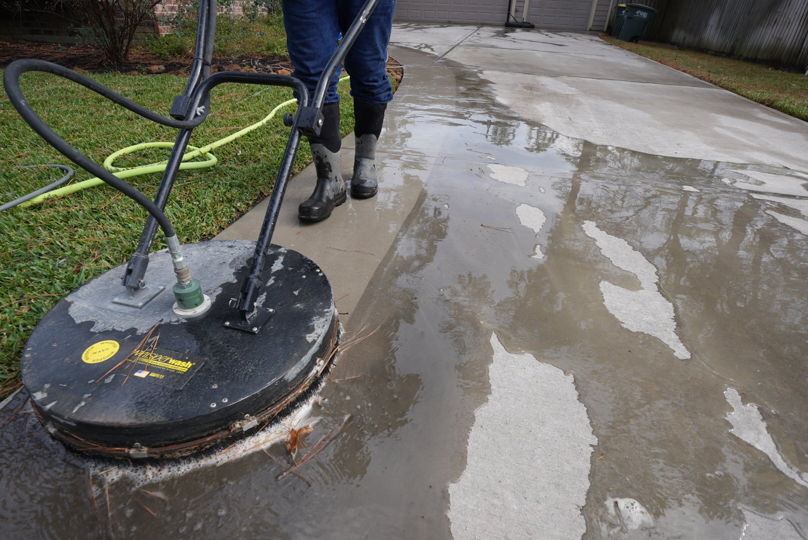Surface cleaner pressure washing a concrete driveway in The Woodlands, TX