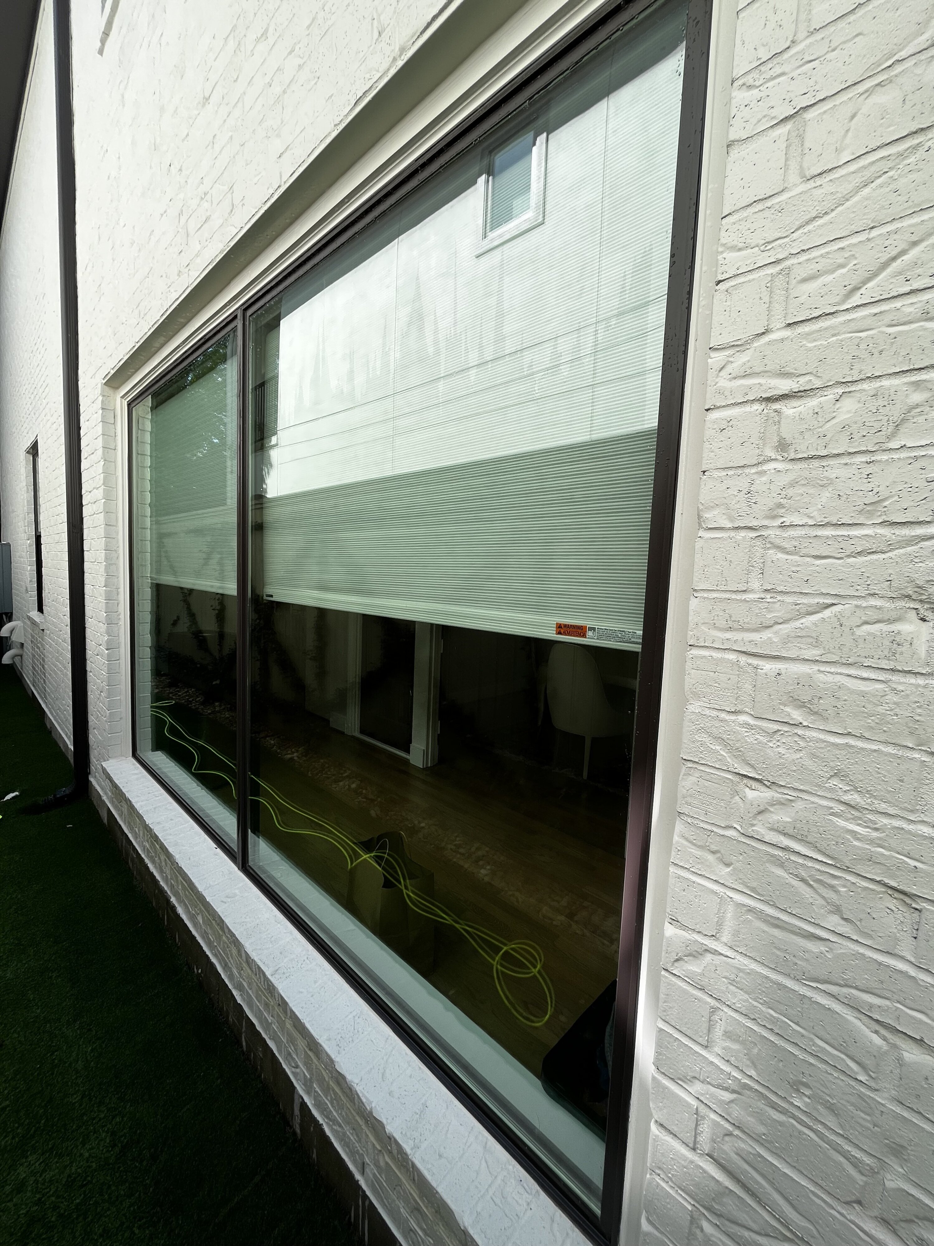 Spotless window and white brick after exterior window cleaning in The Woodlands, TX