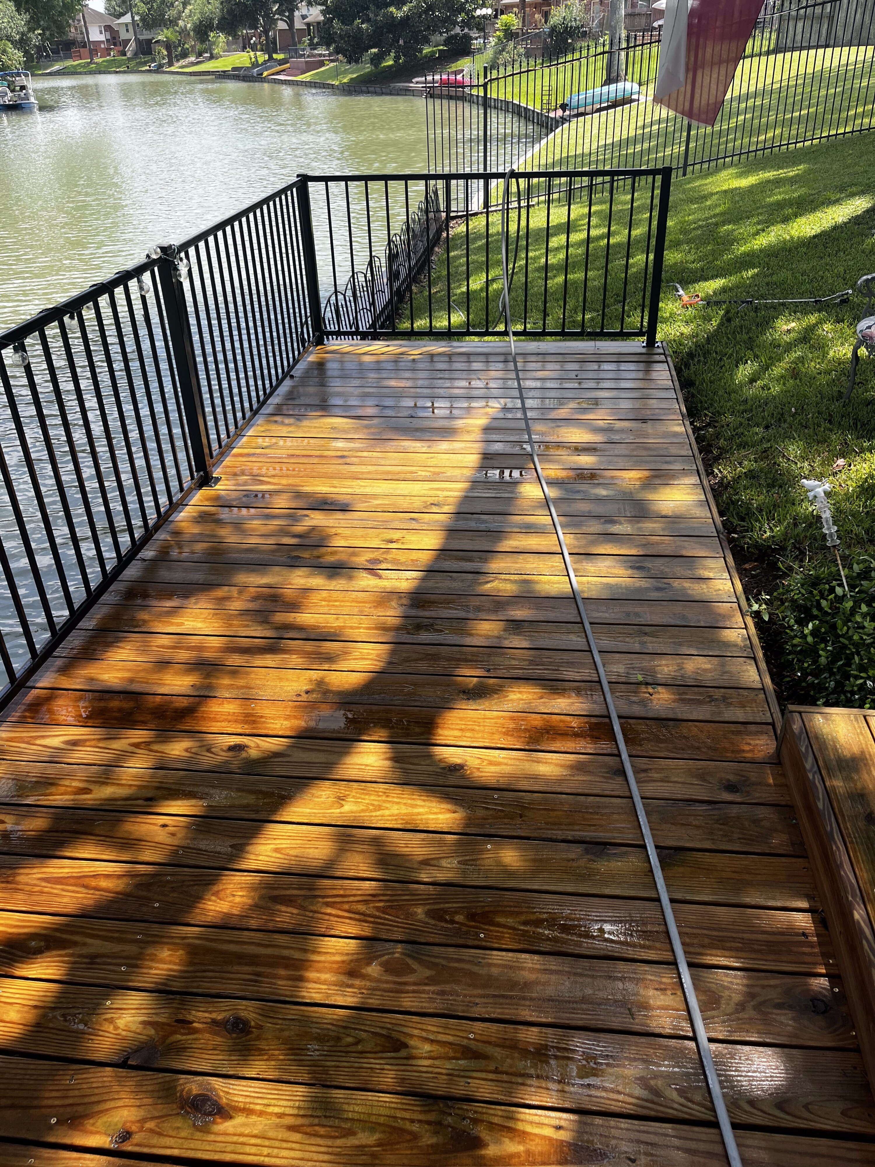 Freshly cleaned wood deck with iron railing in The Woodlands, TX