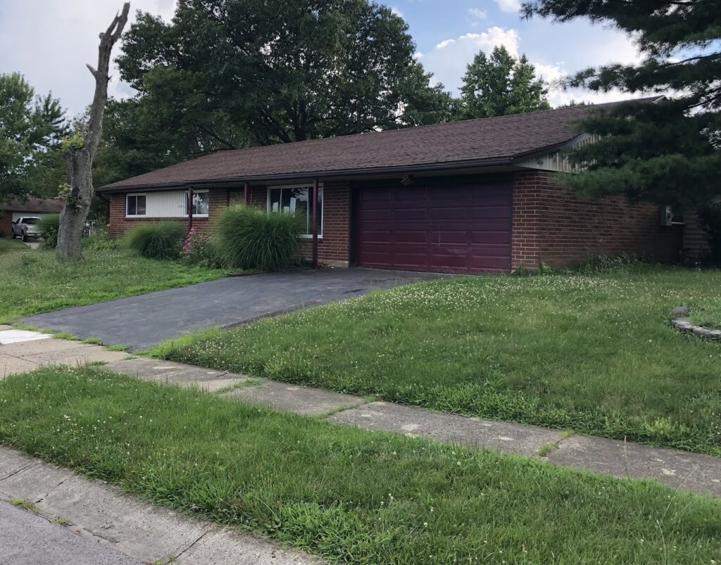 Damaged inherited house exterior in Englewood, Ohio sold as-is to Blad Boys Buy Homes