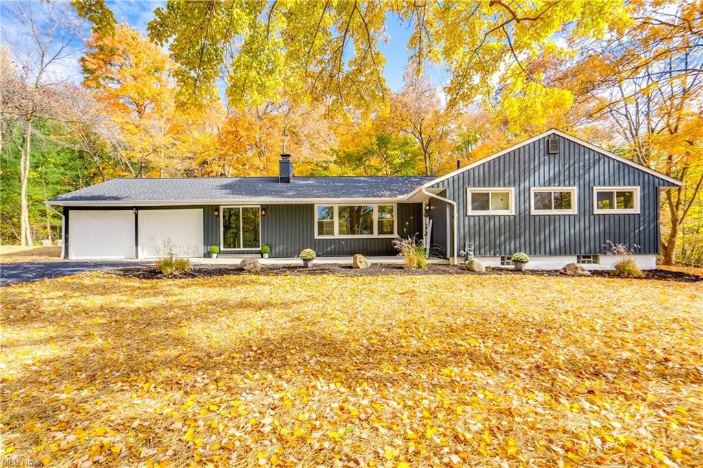 Ranch style house with yellow autumn leaves covering the yard