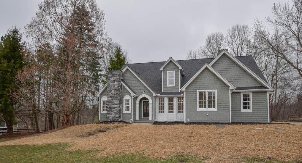 grey house with stone chimney and white trim