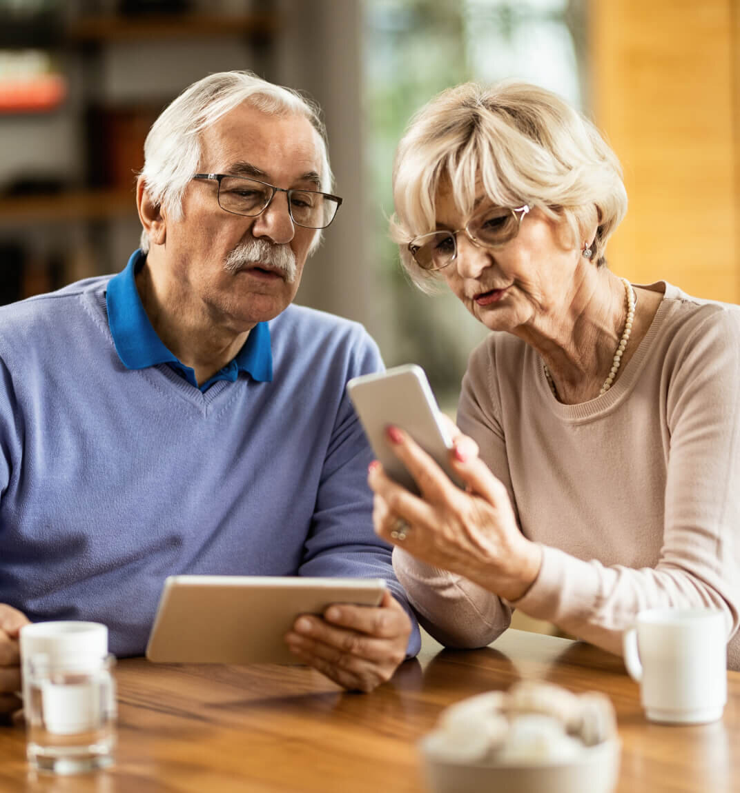 Senior couple reviewing mortgage options on a tablet with guidance from a mortgage broker.