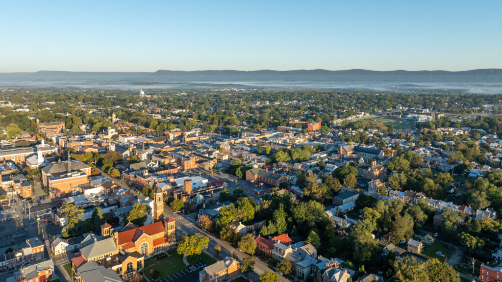 Aerial view o historic buildings, residential areas, and tree-lined streets on a clear day.