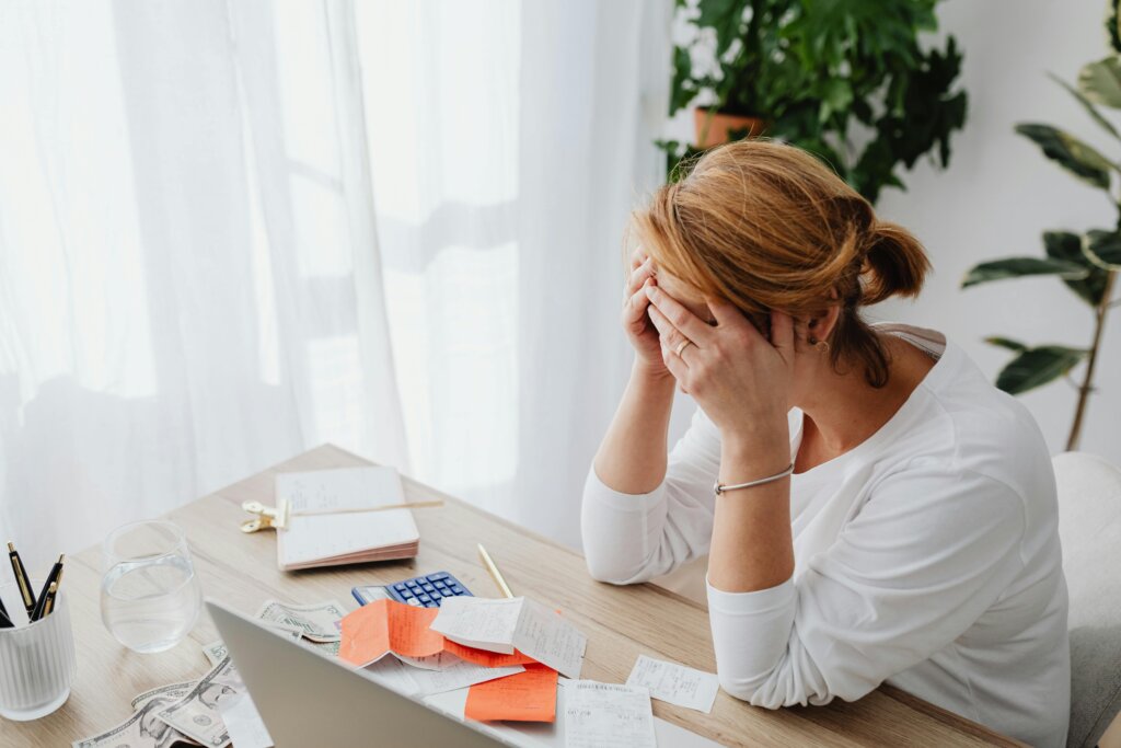 Stressed new homeowner with bills and calculator representing costs of an inherited home