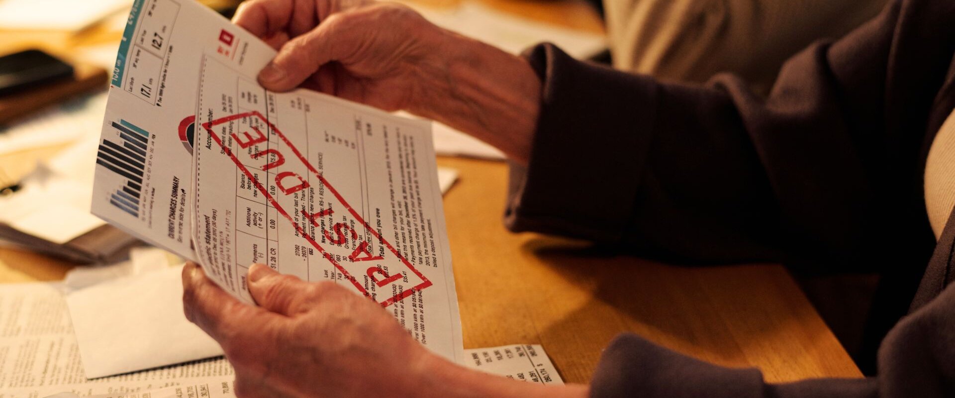 person holding past due bill in Rome, GA.