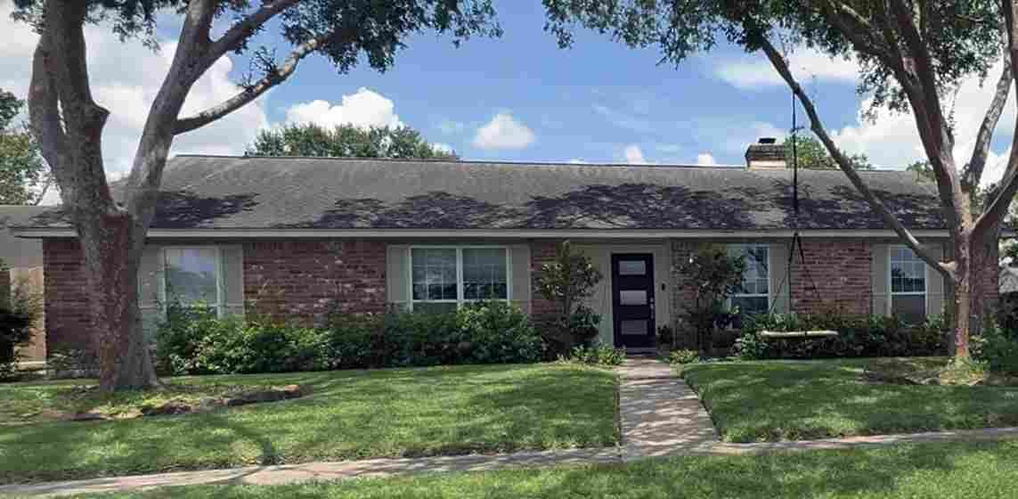 A brick ranch-style home in Houston with mature trees and a well-kept lawn — the kind of family home that often passes from one generation to the next