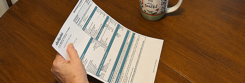 Close-up of hands reviewing mortgage paperwork at a kitchen table