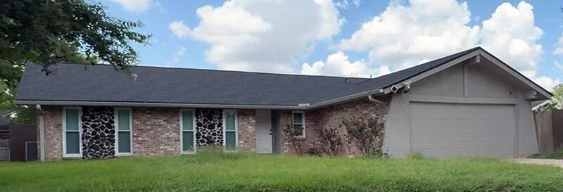 house in southwest houston with overgrown grass in front yard on a sunny day