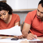 worried couple reviewing bankruptcy paperwork and a court notice at home at the kitchen table