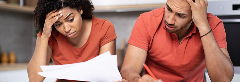 couple reviewing bankruptcy paperwork and a court notice at home at the kitchen table
