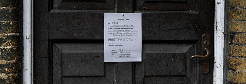 entry notice on wooden exterior door of rental property in Houston