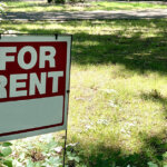 for-rent sign on a grassy suburban houston-lawn in spring