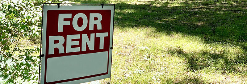 for-rent sign on a grassy suburban houston-lawn in the spring