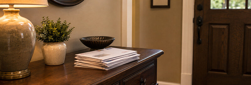 Stack of unopened mail on a home entryway table