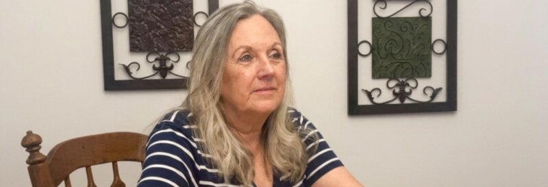 Becky Fields sitting at table talking to a home owner about where we buy houses