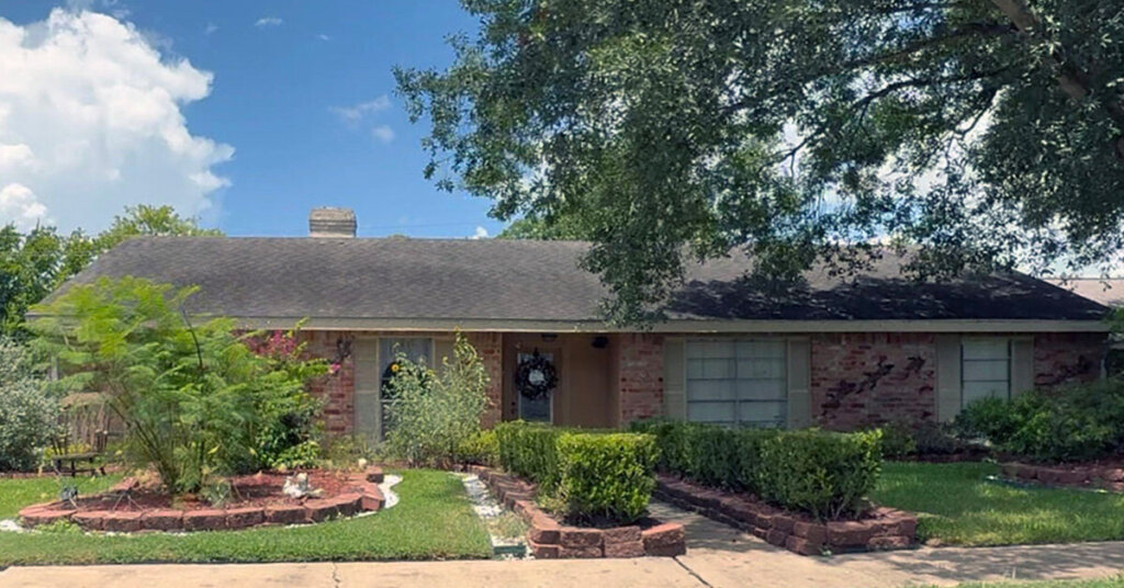 Brick Suburban Ranch House in Richmond TX with white trim and elaborate landscaping in front yard