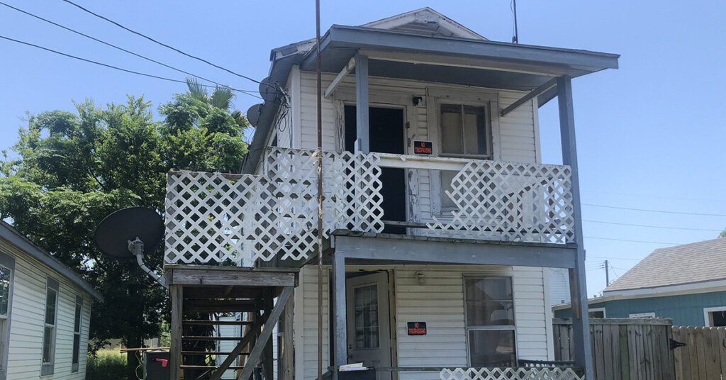 Galveston TX duplex in need of rehab white with blue trim.