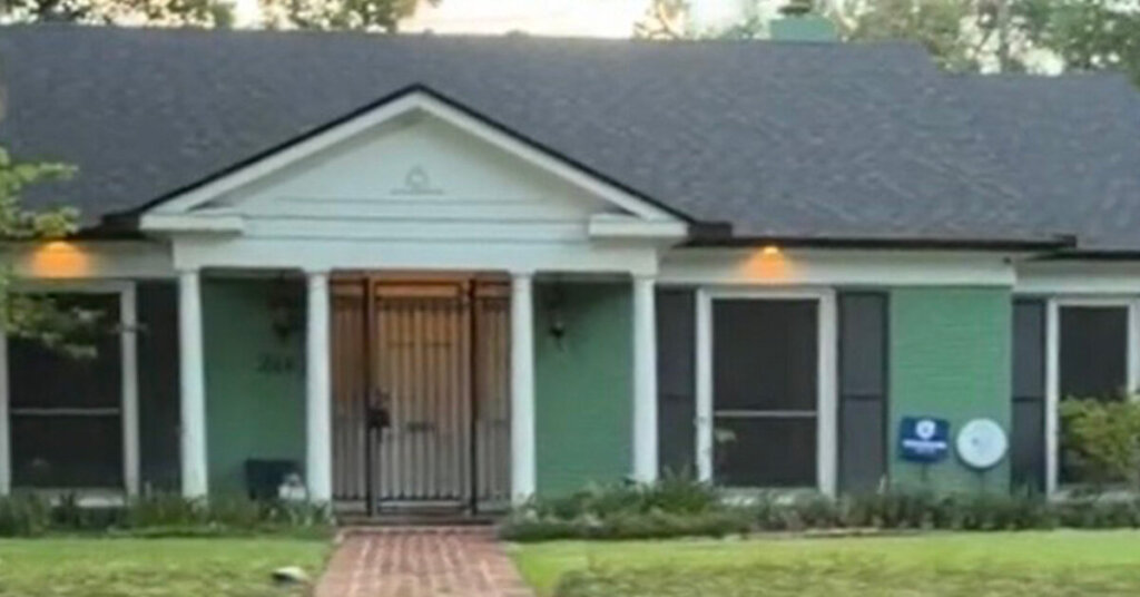 Green Brick Suburban Ranch House in Friendswood TX with mowed front yard on a sunny day