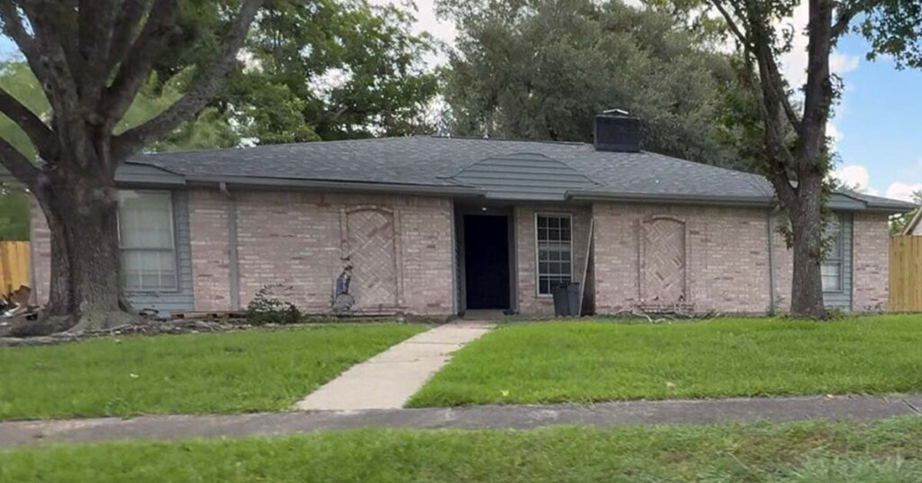 White brick suburban ranch house in Stafford TX with green trim and new roof
