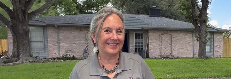 Becky Fields the grandma house buyer in front of a Stafford brick suburban ranch house with green trim and new roof