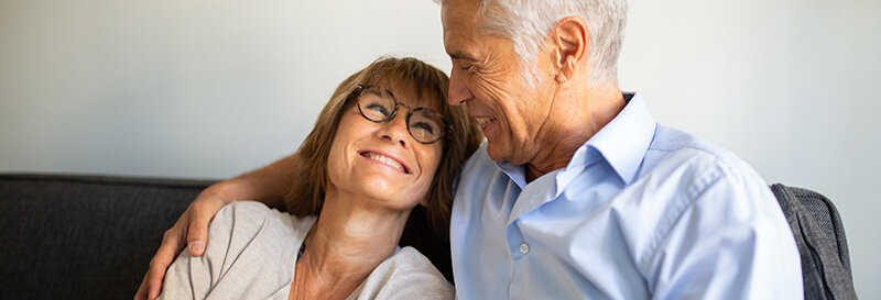 loving couple embracing each other on couch benefiting from knowledge of property capital gains