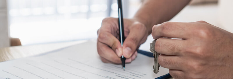 man signing rent to own agreement with sun filled window in background