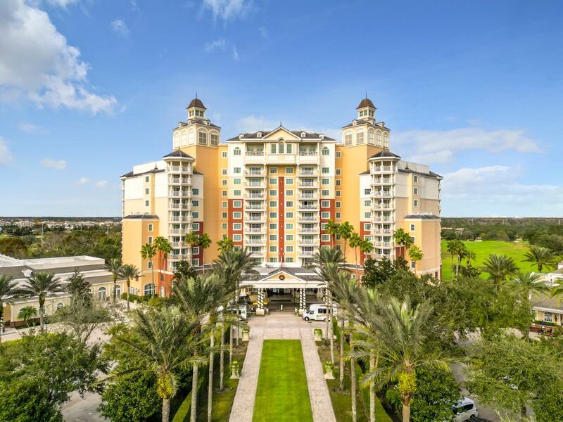 Front view of luxury Reunion Resort hotel building with palm-lined entrance in Florida