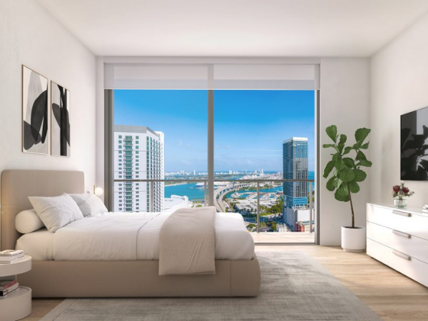 Luxury vacation rental bedroom at The Crosby Miami with bay and skyline views.