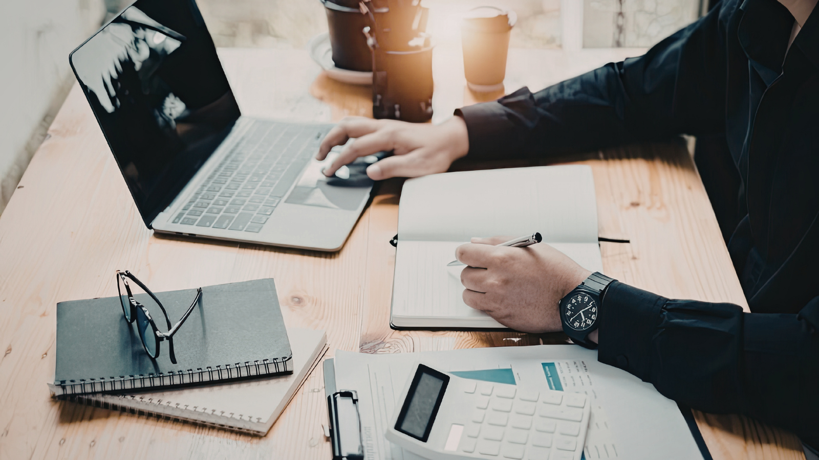 Real estate investor analyzing performance, planning strategy, and calculating Airbnb rental returns using laptop and notebook