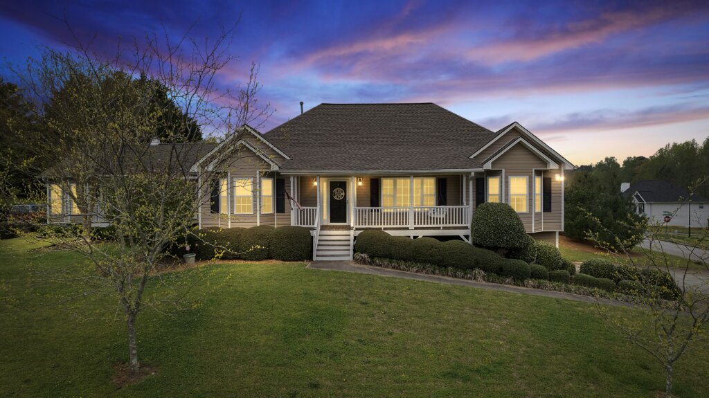 House in Dallas, Georgia during sunset with interior lights on and a vibrant sky.