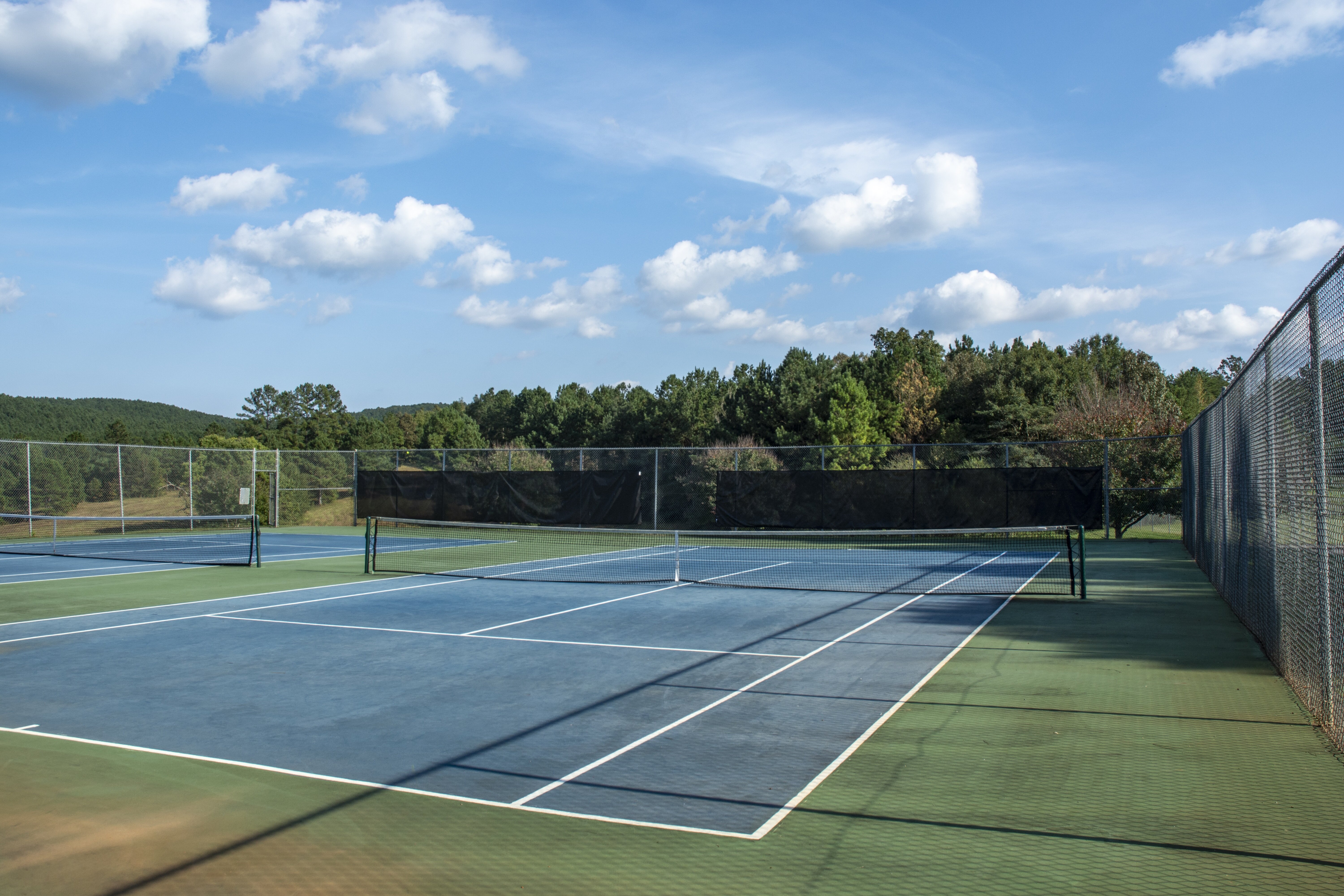 Tennis court in a park located in Floyd County, GA, set within a scenic area, offering a peaceful and active outdoor environment.