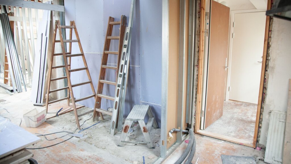Interior of a home under construction showing exposed framing, unfinished walls, and partially built rooms.