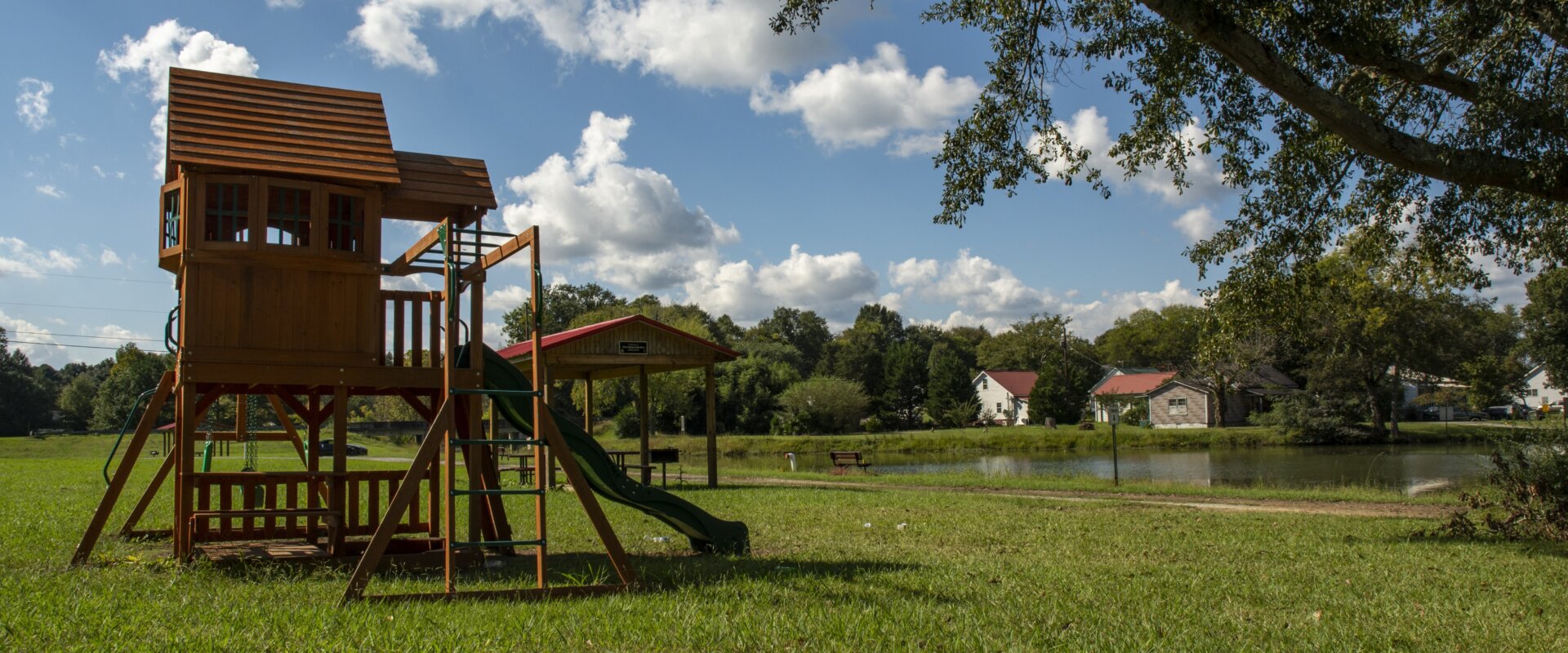 Scenic view of a lake in Floyd County, GA, with a family’s playset in the foreground and homes along the waterfront.