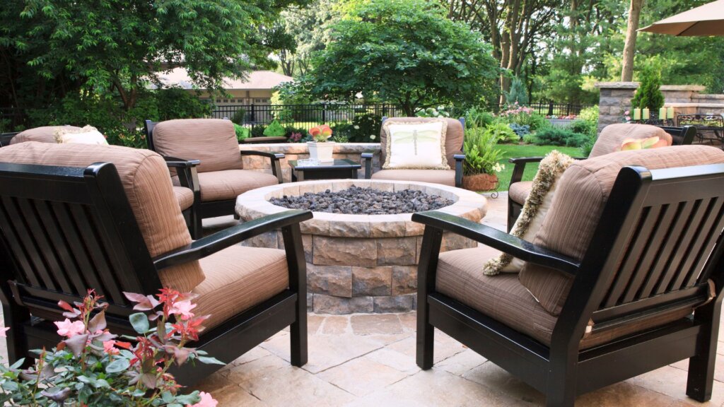 Staged outdoor living space with several chairs around a fire pit
