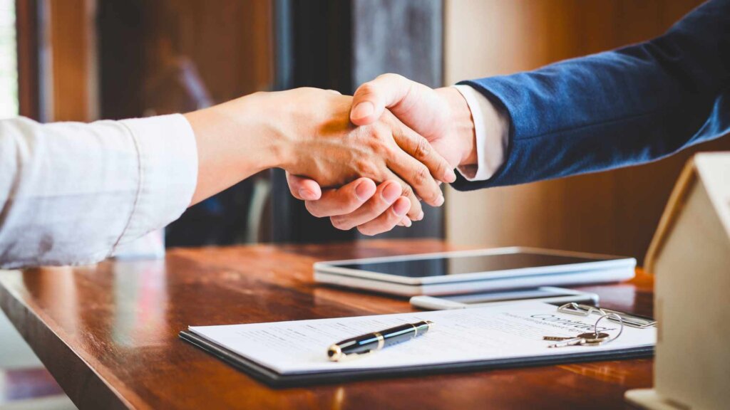 Real estate agent and seller shaking hands