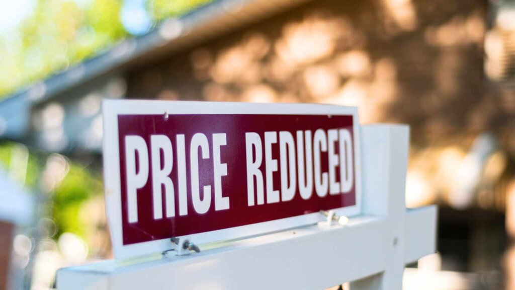 For sale sign with additional price reduction sign