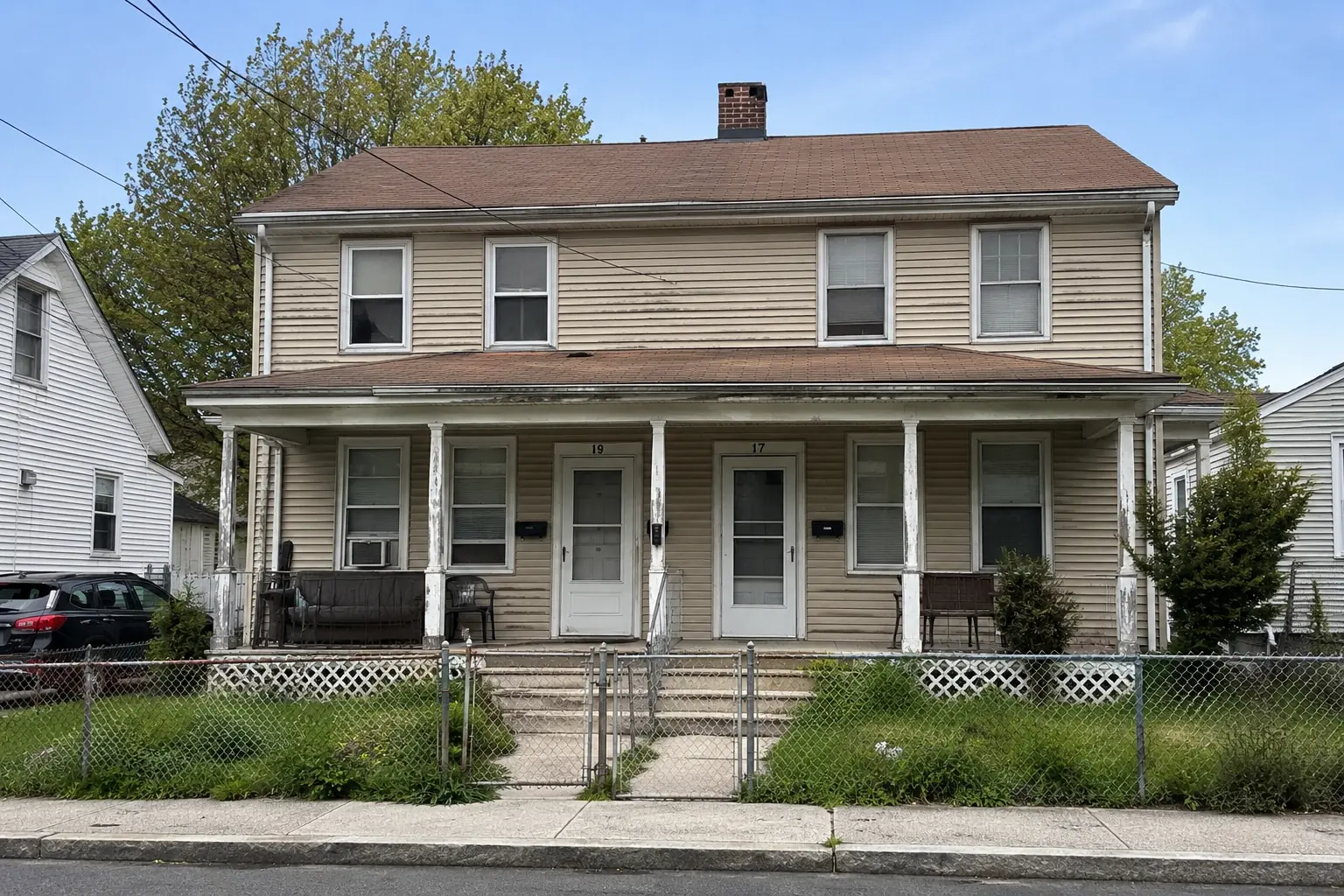 Older two-family home with dated siding in Cranston, Rhode Island