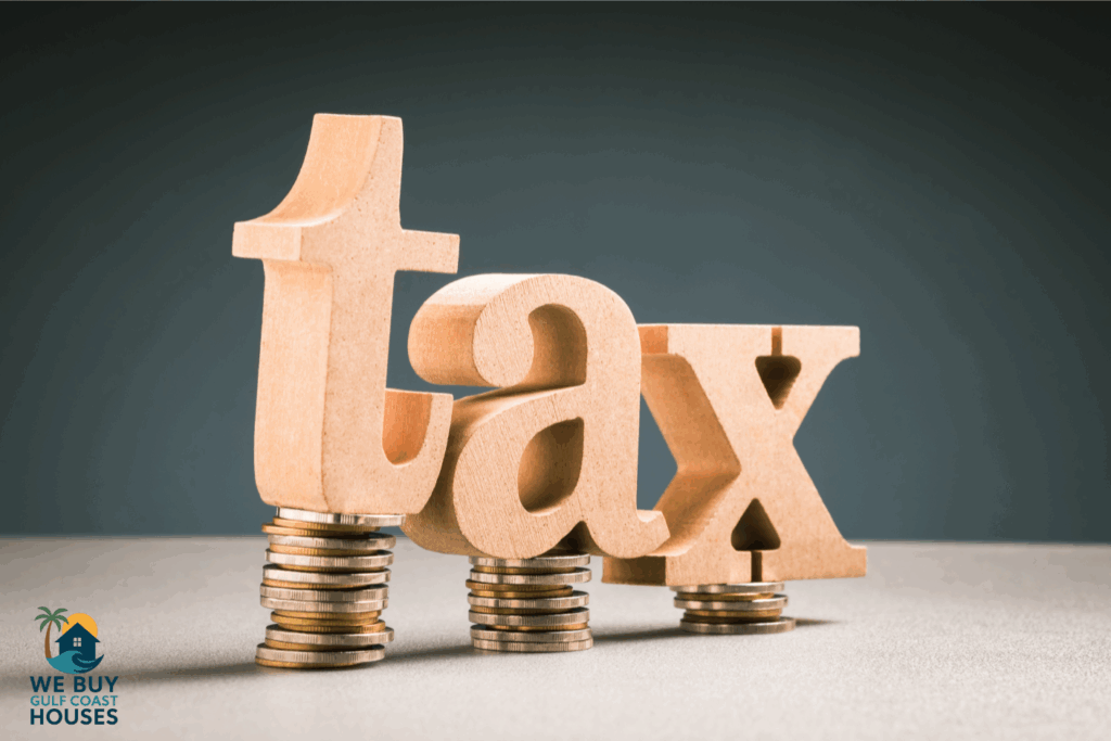 Wooden tax letters on stacks of coins with We Buy Gulf Coast Houses logo
