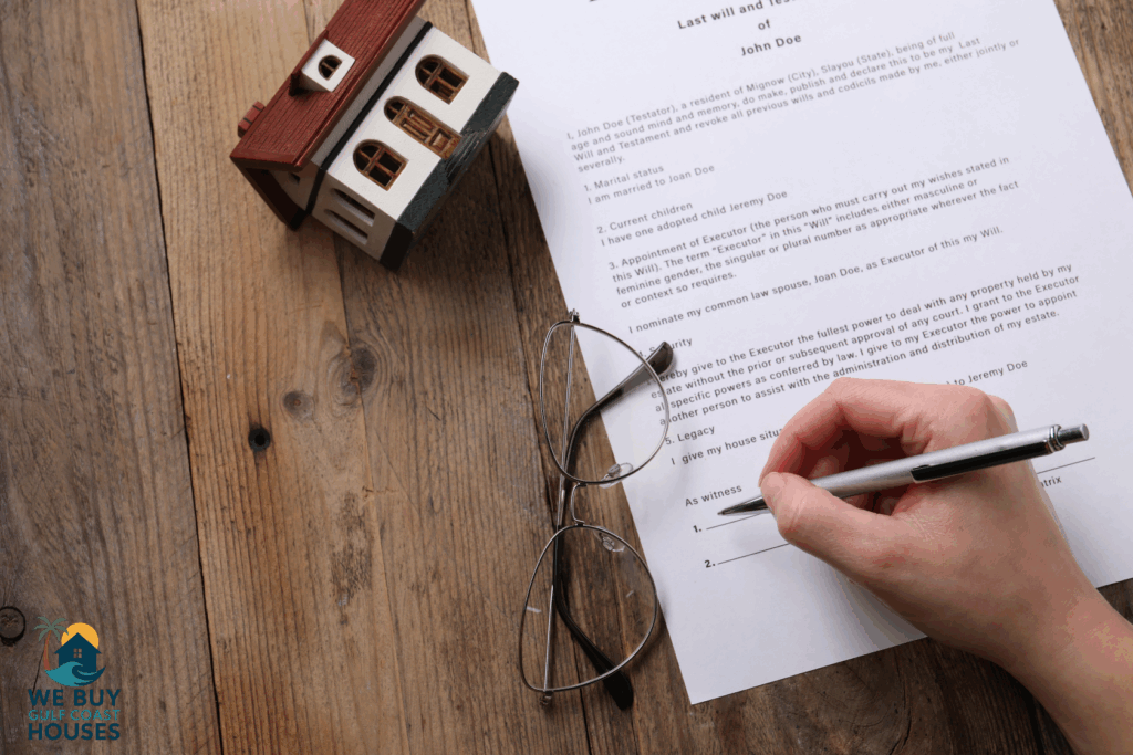 Hand signing last will and testament with house model on wooden table — probate process in Lee County Florida