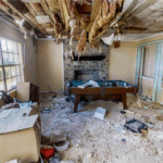 Destroyed rental home interior with ceiling damage, debris, and broken furniture — typical of severe tenant-caused property damage.