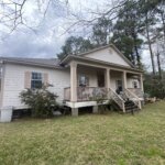 Inherited home in Southeast Louisiana with front porch and mature trees in a quiet Northshore neighborhood